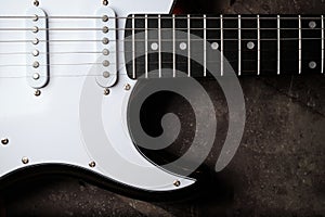Close-up of a fragment of an electric guitar against a dark background. Selective focus