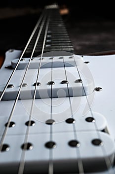 Close-up of a fragment of the pickups and strings of an electric guitar. Selective focus