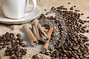 Close up of fragnant cinnamon sticks with coffee beans and cup o