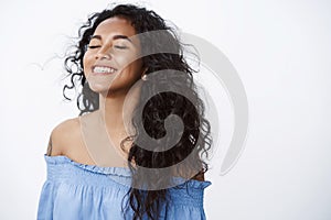 Close-up free and relieved happy attractive, encouraged african american curly-haired woman with tattoos in blue blouse