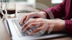 Close up of freelancer's developer hands typing program code on laptop keyboard in coworking. Businessman at work in