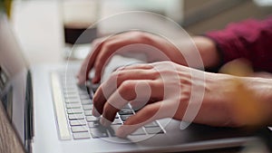Close up of freelancer's developer hands typing program code on laptop keyboard in coworking. Businessman at work in