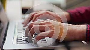 Close up of freelancer's developer hands typing program code on laptop keyboard in coworking. Businessman at work in