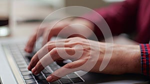 Close up of freelancer's developer hands typing program code on laptop keyboard in coworking. Businessman at work in