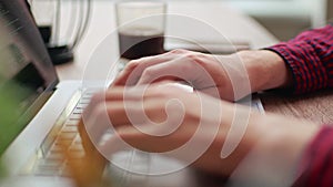 Close up of freelancer's developer hands typing program code on laptop keyboard in coworking. Businessman at work in