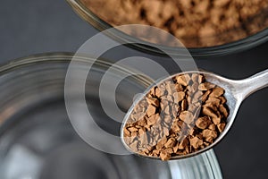 Close up, Freeze Dried Instant Coffee on Tea Spoon with Glass Coffee Cup Background