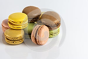 Close-up of French dessert for coffee. Multicolored macarons on white background