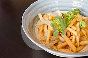 Close up French fries are prepared in a cup and ready to be served.