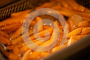 Close-up frenchfries in eclectric pan with boiling oil