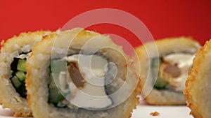 Close-up of a fresh baked sushi set that rotate on a bright orange background. Restaurant food. Asian cuisine. Shallow depth of fi