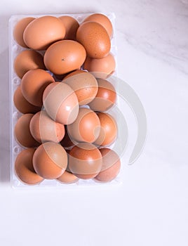 Close-up of fresh brown eggs in a plastic box ,copy space