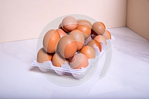 Close-up of fresh brown eggs in a plastic box ,copy space