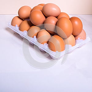 Close-up of fresh brown eggs in a plastic box ,copy space