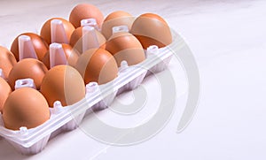Close-up of fresh brown eggs in a plastic box ,copy space