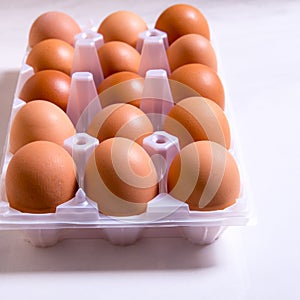 Close-up of fresh brown eggs in a plastic box ,copy space