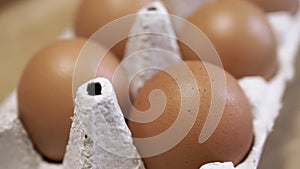 Close up, Fresh Chicken Eggs in a Cardboard Tray on a Rotating Wooden Background