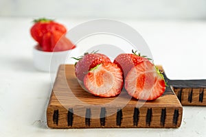 Close up of fresh cut strawberry served on wooden desk on white background