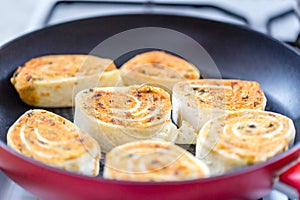 Close up of fresh grilled tortilla wraps with filling. Fried tortilla rolls in a pan. Selective focus