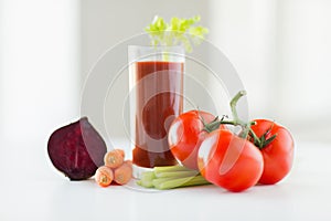 Close up of fresh juice and vegetables on table