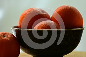 Close up of fresh and juicy bright orange mandarins on a dark background; shallow depth of field