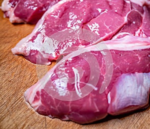 Close up of fresh, lean lamb meat on a wooden cutting board