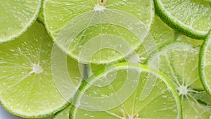 Close up of fresh lime slices as a background. green background with citrus fruit of lime slices. rotating on white background.