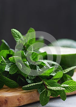 Close-up of fresh mint and lime on a wooden cutting board on a table