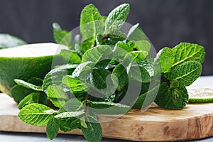 Close-up of fresh mint and lime on a wooden cutting board on a table