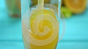 Close up on fresh orange juice filling a glass