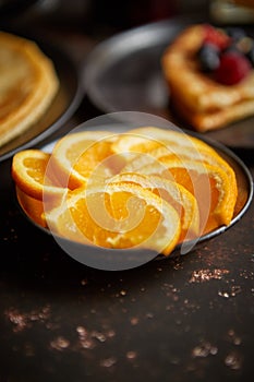 Close up on fresh orange slices placed on ceramic saucer