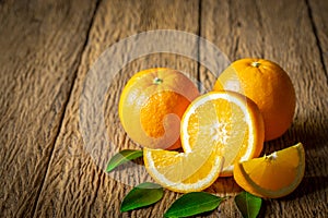 Close-up of Fresh oranges, half-cut fruit, slice with green leaves on an old wood vintage table.