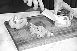 Close up of fresh paprika being cut on wooden board