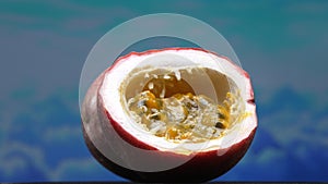 Close up of fresh passion fruit, bursting with sky-blue background. Comestible.