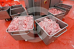 View of a many metallic boxes with chopped fresh raw meat, stored in a meat factory, industry process. Horizontal view