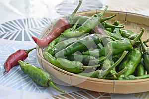 Close-up of fresh red and green peppers stacked on bamboo baskets