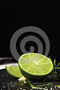 Close-up of fresh, ripe, juicy half of a green lime on a black background. Citrus fruit full of vitamins. Copy space.