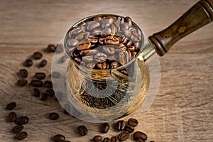 Close up of fresh roasted coffe beans in  cezve traditional turkish coffee pot on wooden table