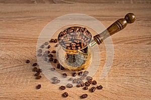 Close up of fresh roasted coffe beans in  cezve traditional turkish coffee pot on wooden table