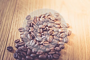 Close up of fresh roasted coffee beans on wooden background