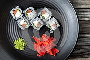 Close-up of fresh rolls and sushi set, with salmon, sprinkled with black caviar. Tasty food.