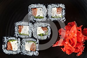 Close-up of fresh rolls and sushi set, with salmon, sprinkled with black caviar. Tasty food.
