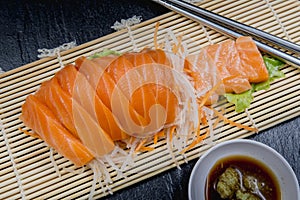 Close up fresh salmon sashimi set salad on bamboo plate, Japanese food.