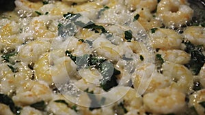 Close-up of fresh shrimps with basil fried in oil on a frying pan. Concept. Delicious seafood