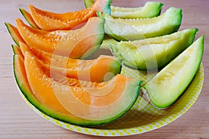 Close up fresh sliced melon with plate on wooden background at melon farm in Furano, Hokkaido, Japan.