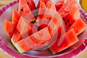 Close up fresh sliced watermelon with plate on wooden background at melon farm in Furano, Hokkaido, Japan.