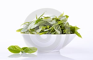 Close up fresh tea leaves in white bowl