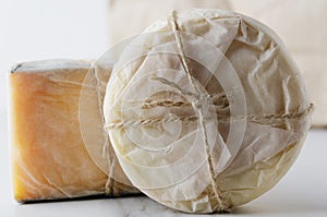 Close up of fresh wrapped in paper cheese.Traditional italian cheese.Various typies of cheese photo