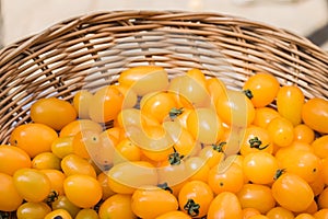 Close up fresh yellow cherry tomato in basket.