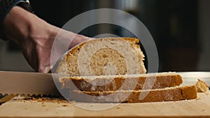 Close Up of freshly baked bread being sliced with a bread knife in Slow Motion.