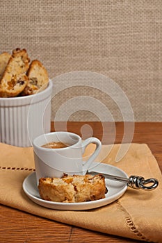 Close up of a freshly baked, homemade, apricot ginger, walnut biscotti and cup of espresso